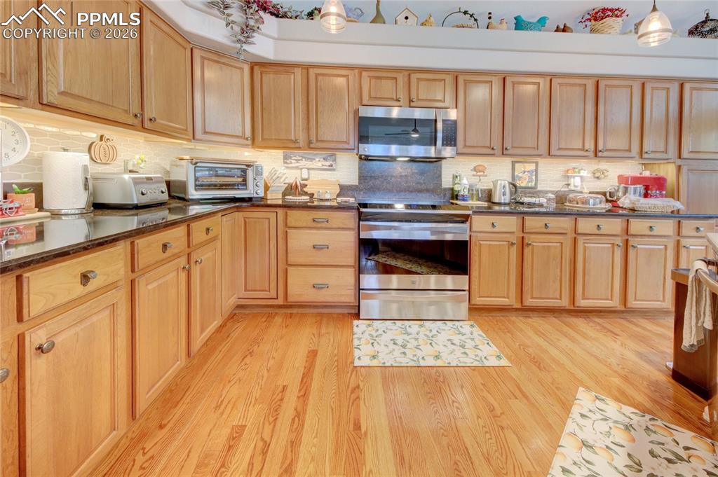 Image 5 of 50: Kitchen hardwood floors and hickory cabinetry