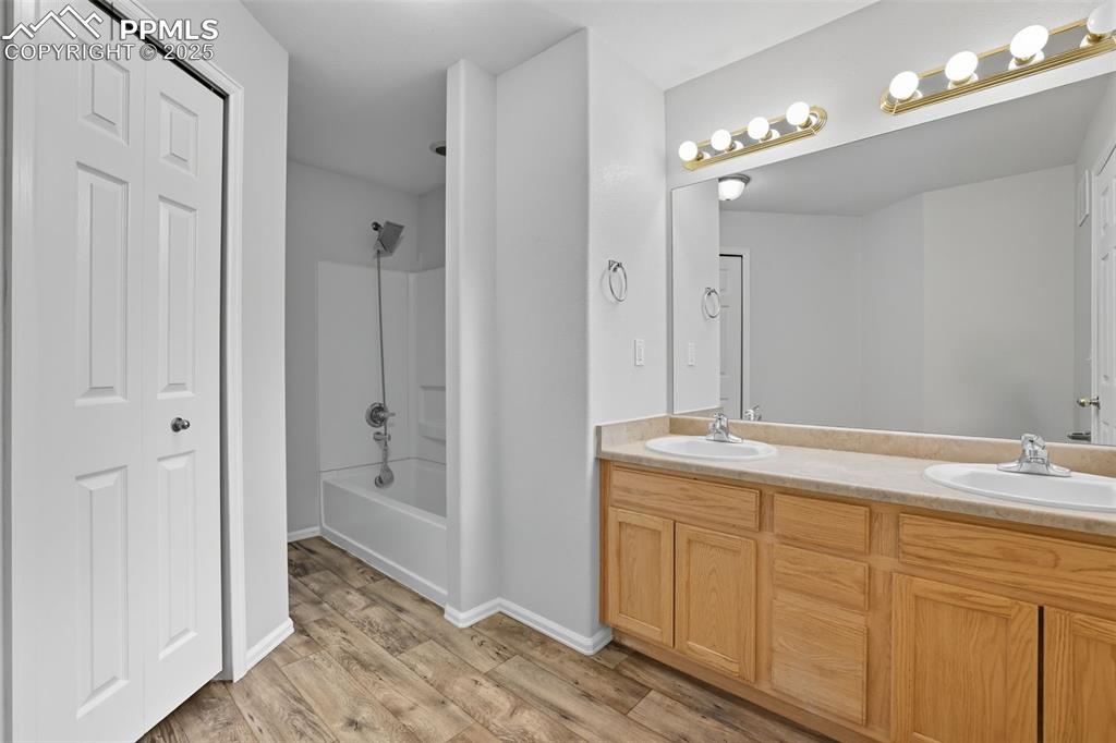 Image 28 of 47: Bathroom with shower / washtub combination, double vanity, a closet, and la