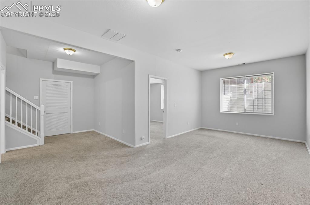 Image 36 of 47: Spare room featuring stairway and light colored carpet