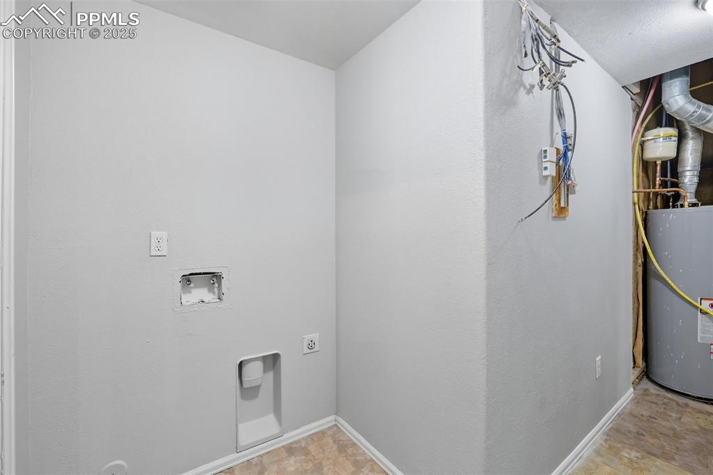 Image 43 of 47: Laundry area featuring water heater, washer hookup, and hookup for an elect