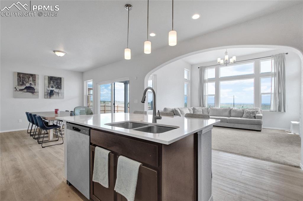 Image 11 of 41: Kitchen featuring arched walkways, dark brown cabinetry, open floor plan, l