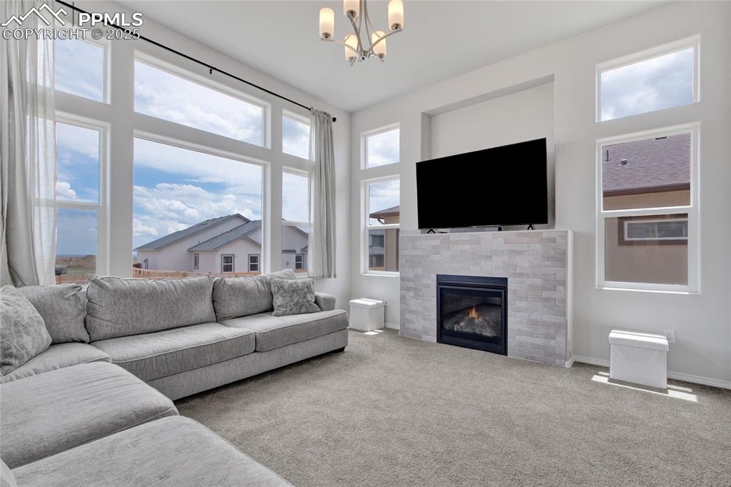 Image 12 of 41: Living room featuring a chandelier, carpet flooring, healthy amount of natu