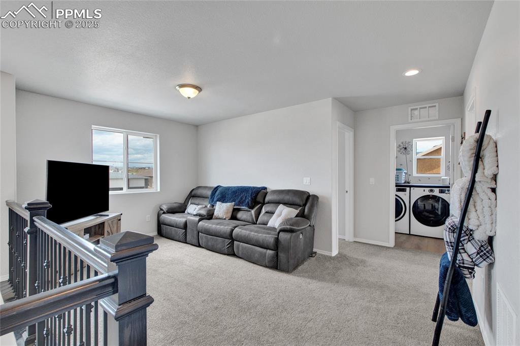 Image 19 of 41: Carpeted living area featuring independent washer and dryer and recessed li