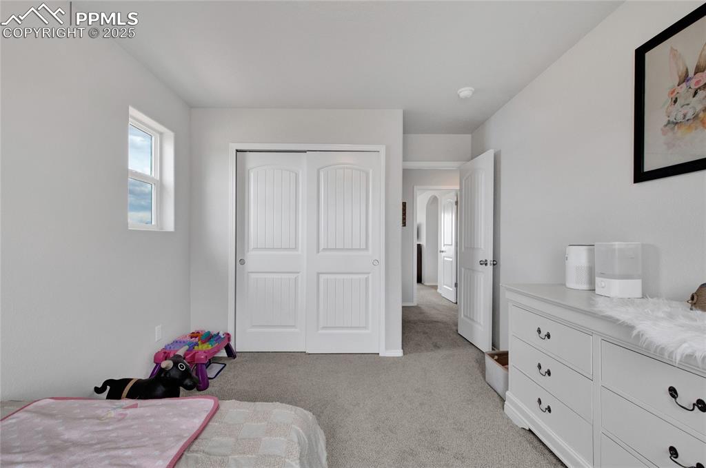 Image 29 of 41: Bedroom with light colored carpet and a closet
