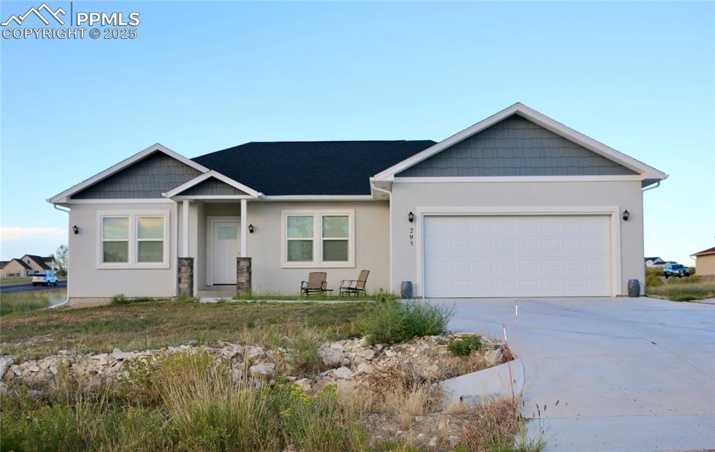 Caption: View of front of property featuring stucco siding, concrete driveway, and a garage