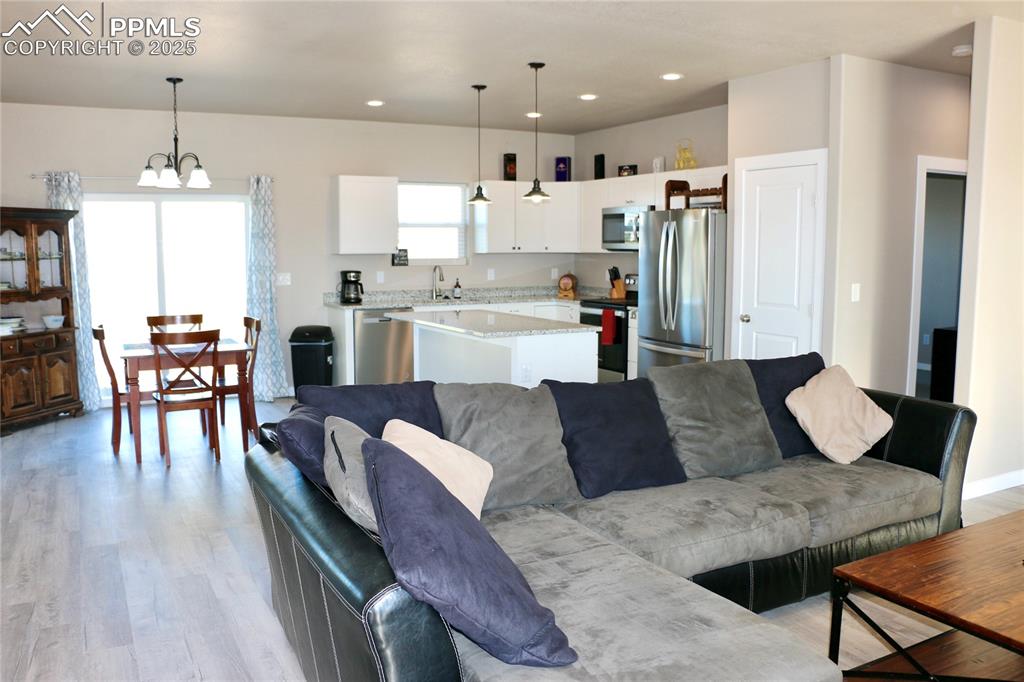 Image 18 of 28: Living area featuring light wood-style floors, a chandelier, and recessed l