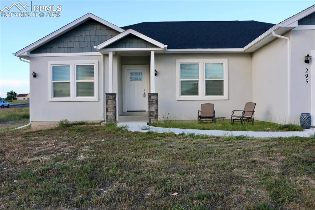 Image 22 of 28: Craftsman-style house featuring stucco siding and a front lawn