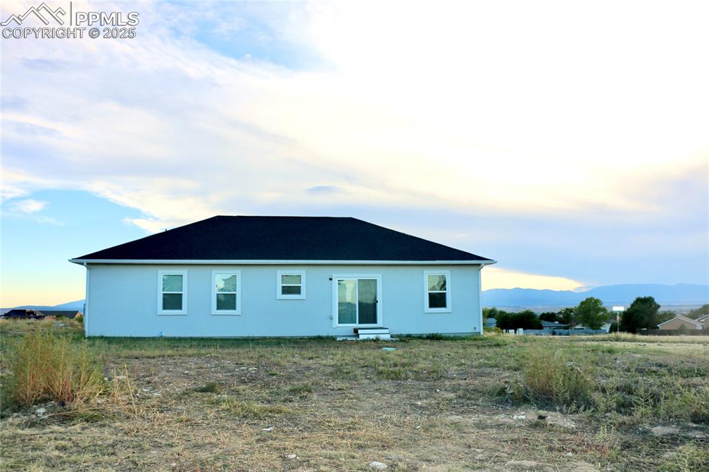 Image 23 of 28: Rear view of house with a mountain view and stucco siding