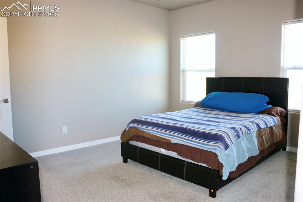 Image 7 of 28: Bedroom with baseboards and carpet flooring