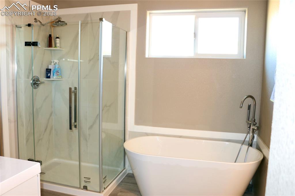 Image 9 of 28: Bathroom with a freestanding tub, a marble finish shower, and vanity
