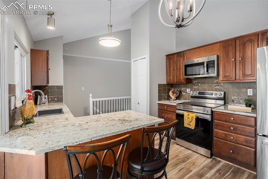 Image 12 of 34: Kitchen featuring appliances with stainless steel finishes, light wood-styl