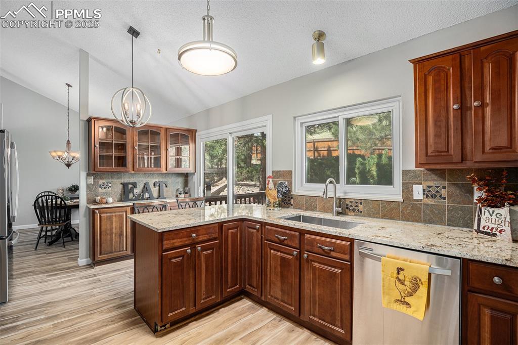 Image 14 of 34: Kitchen with appliances with stainless steel finishes, lofted ceiling, a ch