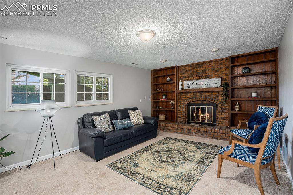Image 24 of 34: Family room with a brick fireplace, and built in features