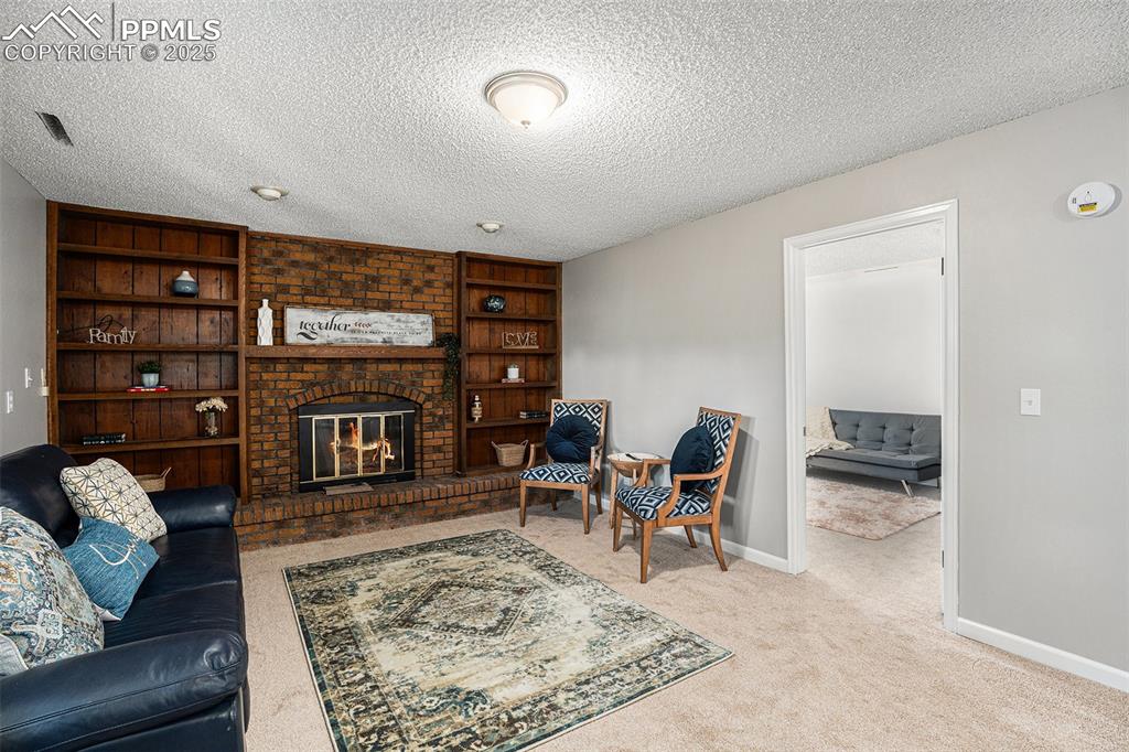 Image 25 of 34: Family room with a brick fireplace, and built in features
