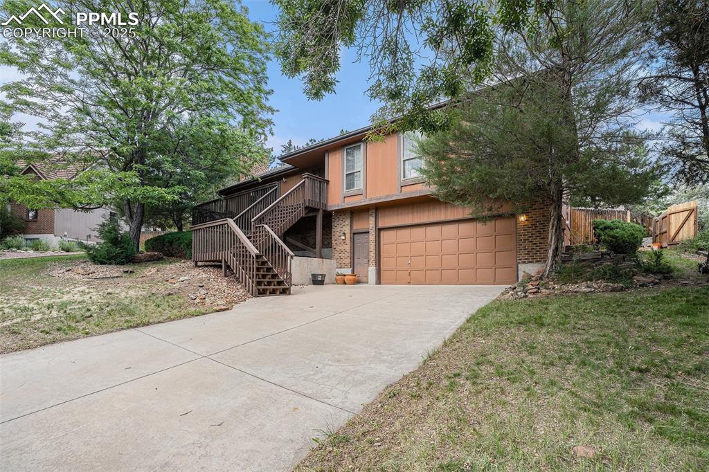 Image 3 of 34: View of front of property featuring an attached garage, concrete driveway, 