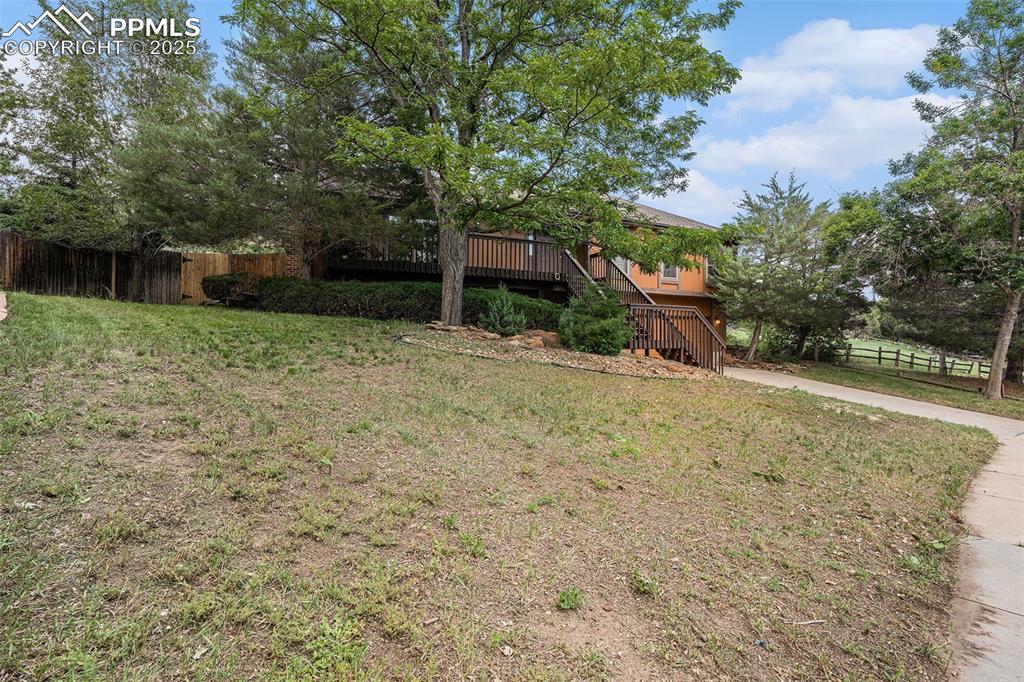 Image 4 of 34: View of yard with stairway and a wooden deck