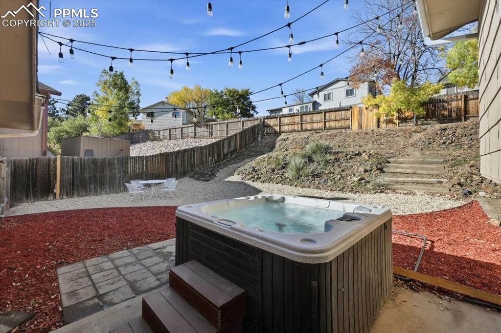 Image 47 of 47: Fenced backyard with hot tub.