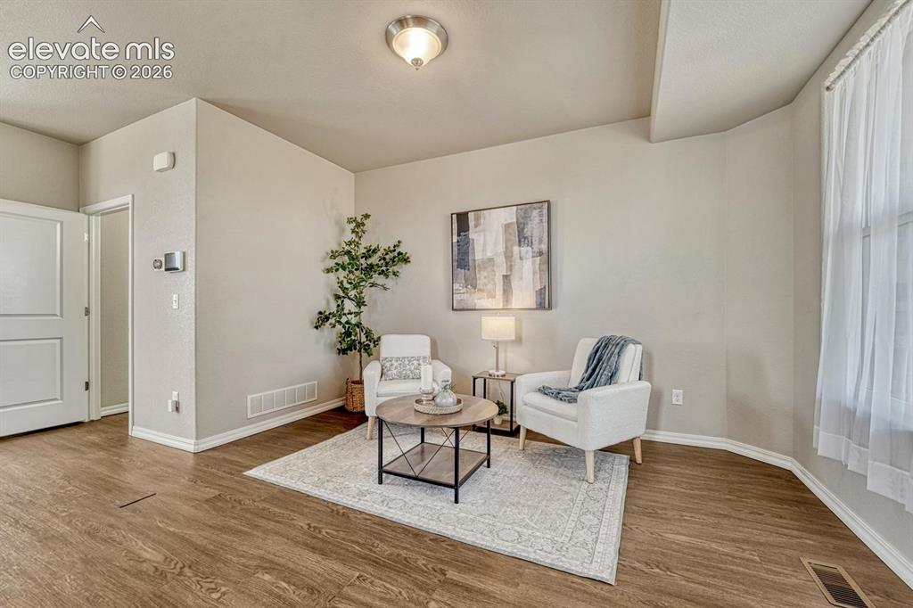 Image 11 of 40: The formal Living Room has front yard views and attractive wood laminate fl