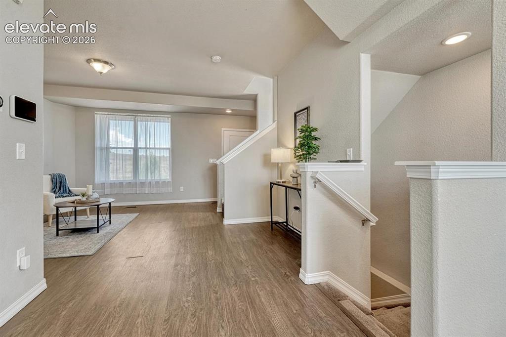 Image 14 of 40: View into the formal Living Room from the Dining Area with stairs to the ga