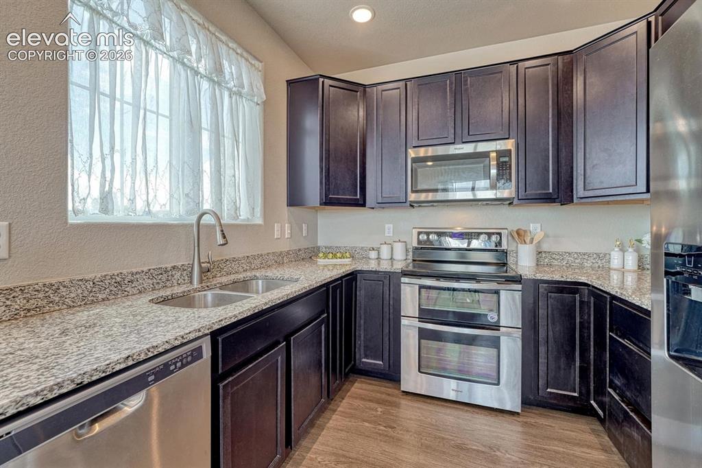 Image 16 of 40: The Kitchen features dark wood cabinetry, granite countertops, and stainles