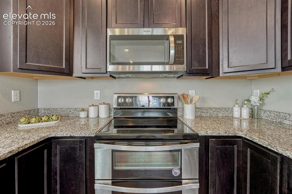 Image 17 of 40: Stainless steel appliances include a smooth top range with double oven, mic