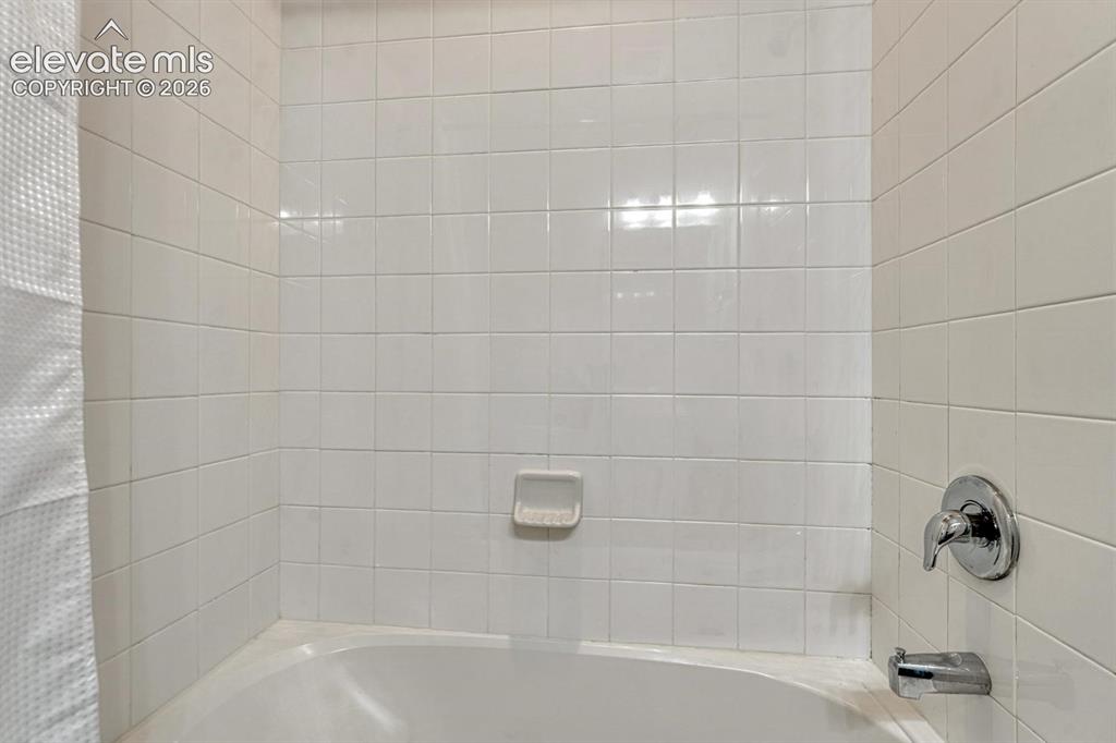 Image 31 of 40: Tiled tub/shower in the upper level hall bathroom.
