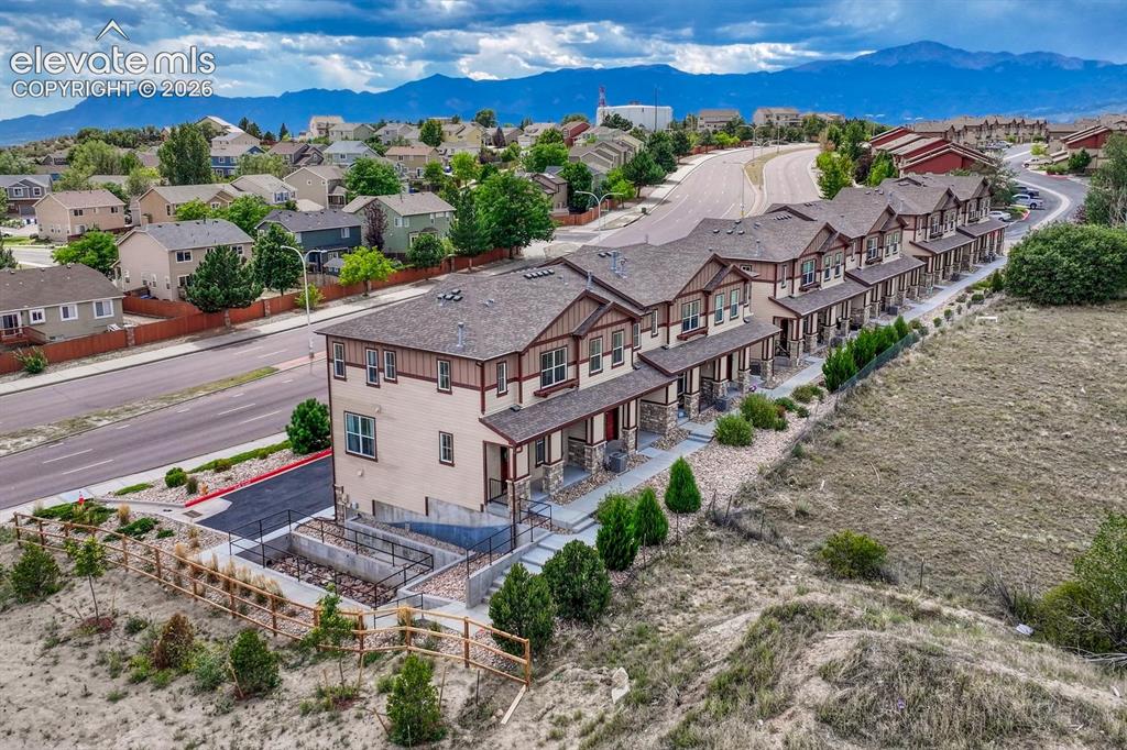 Image 34 of 40: Aerial view of complex, neighborhood, and mountain views.
