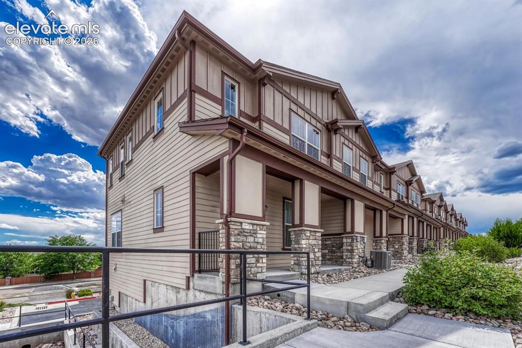 Image 9 of 40: Front view of end unit townhome with covered front porch.