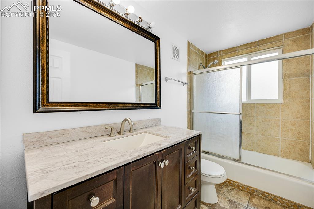 Image 18 of 29: Bathroom featuring vanity and shower / bath combination with glass door
