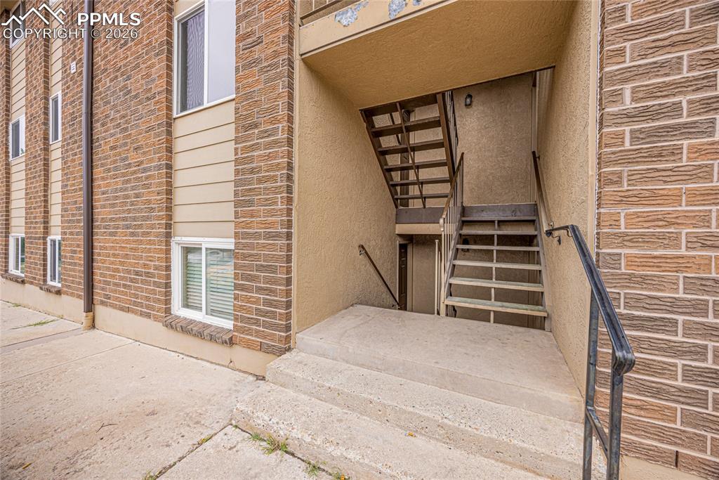 Image 2 of 29: Doorway to property featuring stucco siding and brick siding