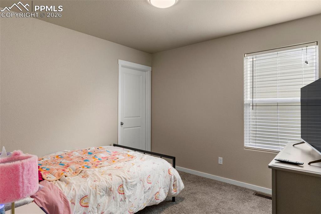Image 14 of 32: Bedroom with light colored carpet and baseboards