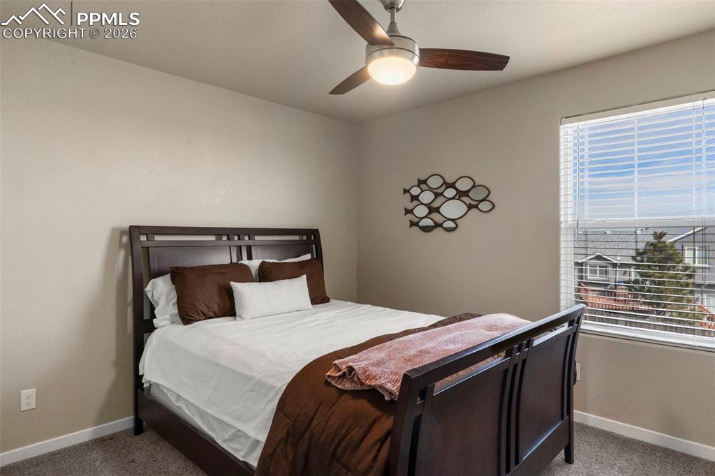 Image 16 of 32: Carpeted bedroom with baseboards and ceiling fan