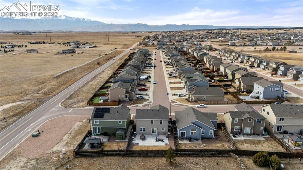 Image 30 of 32: Aerial view of residential area featuring a mountainous background