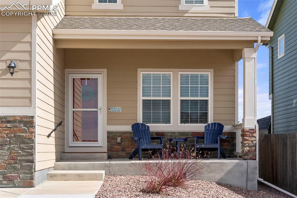 Image 32 of 32: View of exterior entry featuring stone siding and a shingled roof