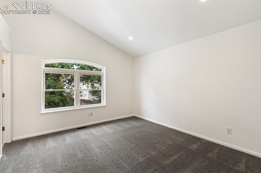 Image 19 of 27: Spare room featuring dark carpet, high vaulted ceiling, and recessed lighti