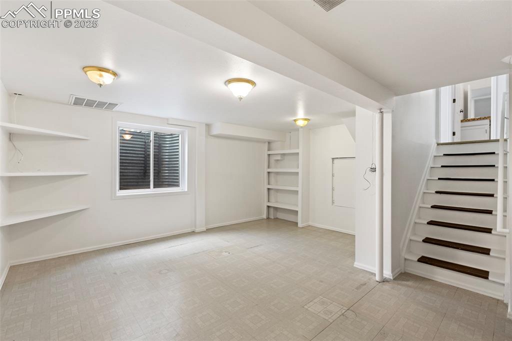 Image 24 of 27: Below grade area with stairway and baseboards