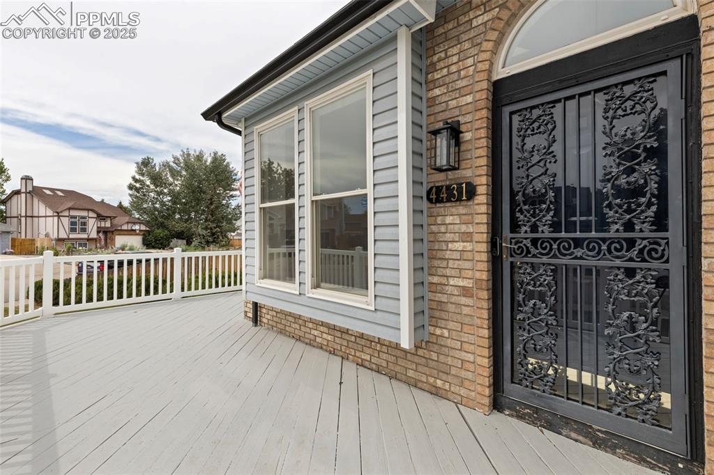 Image 4 of 27: Property entrance featuring brick siding and a deck