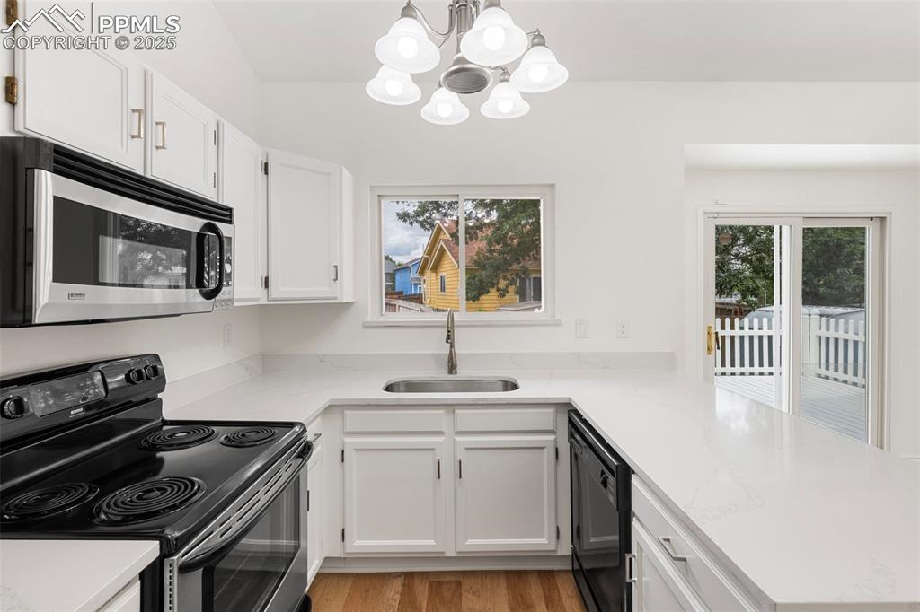 Image 9 of 27: Kitchen with electric range oven, stainless steel microwave, healthy amount