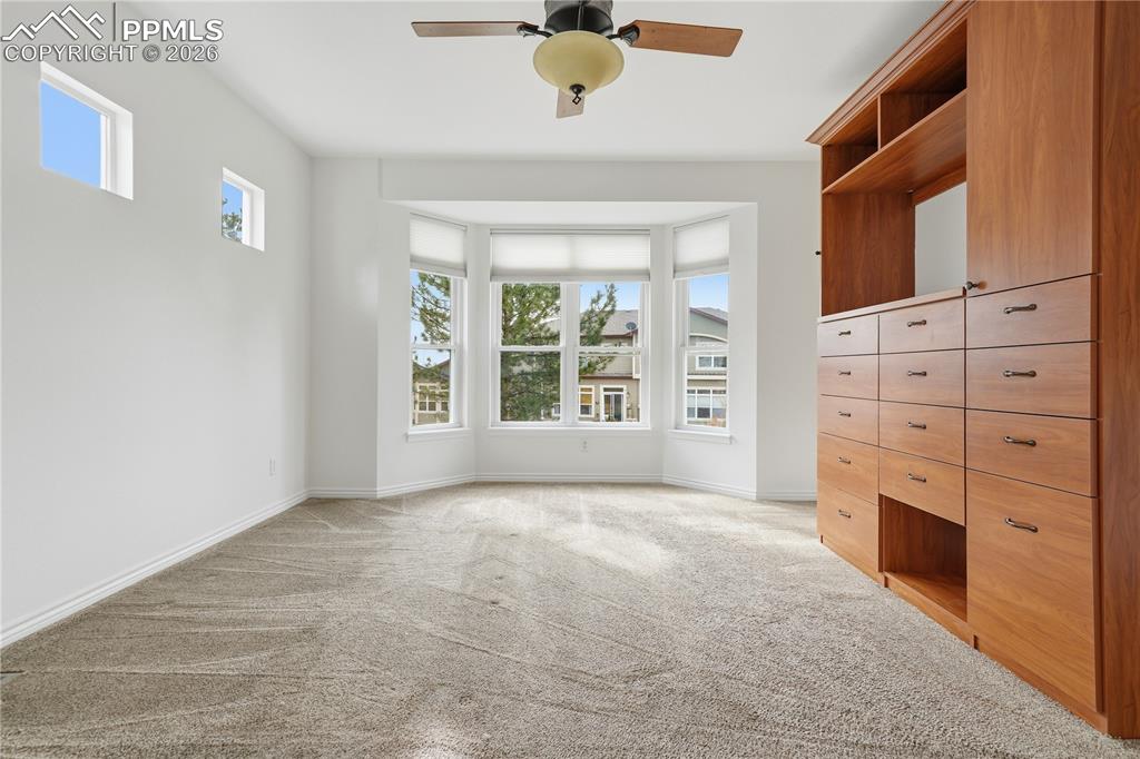 Image 13 of 41: Main level primary suite with custom built wardrobe