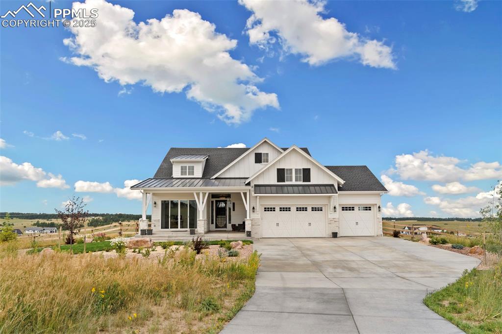 Image 10 of 50: View of front of home featuring covered porch, a standing seam roof, a meta