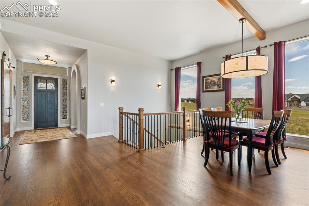 Image 11 of 50: Dining room featuring dark wood finished floors and beamed ceiling