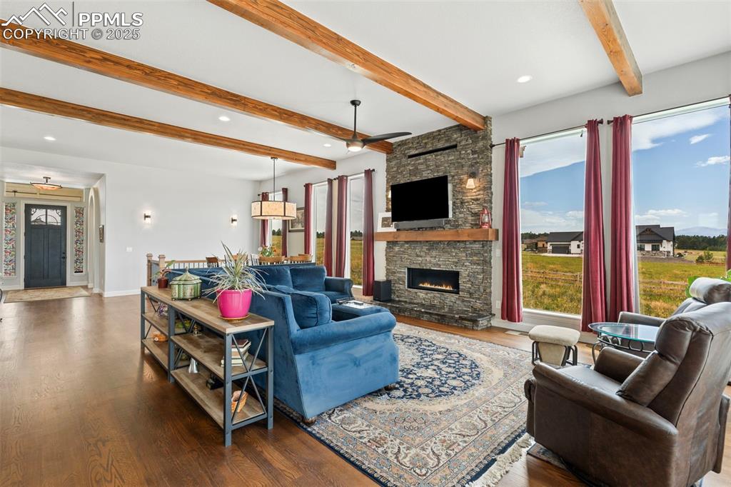 Image 14 of 50: Living room featuring beam ceiling, healthy amount of natural light, wood f