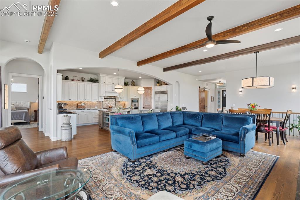 Image 15 of 50: Living room featuring arched walkways, dark wood-type flooring, recessed li