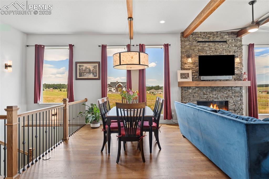 Image 17 of 50: Dining room with a stone fireplace, wood finished floors, healthy amount of