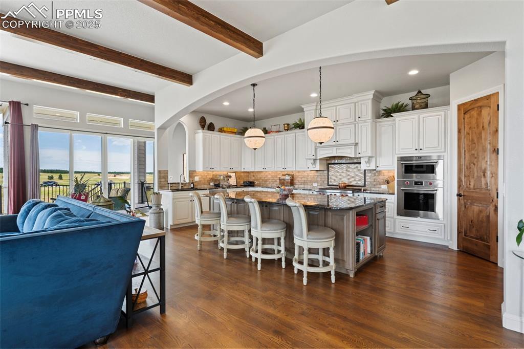 Image 18 of 50: Kitchen featuring pendant lighting, a breakfast bar, a kitchen island, whit