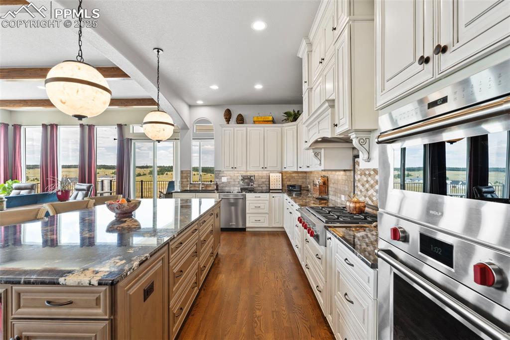Image 22 of 50: Kitchen featuring stainless steel appliances, decorative light fixtures, be