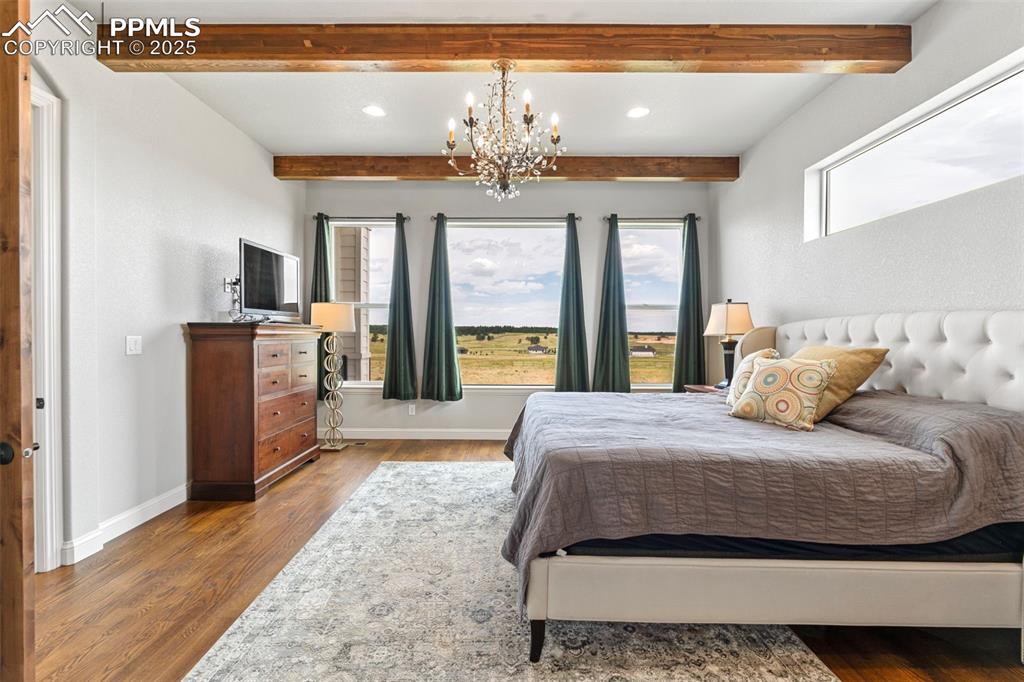 Image 29 of 50: Bedroom featuring wood finished floors, beam ceiling, a chandelier, and rec
