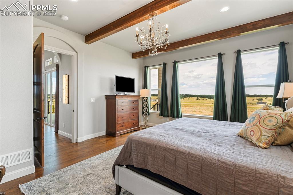 Image 30 of 50: Bedroom featuring dark wood finished floors, arched walkways, recessed ligh
