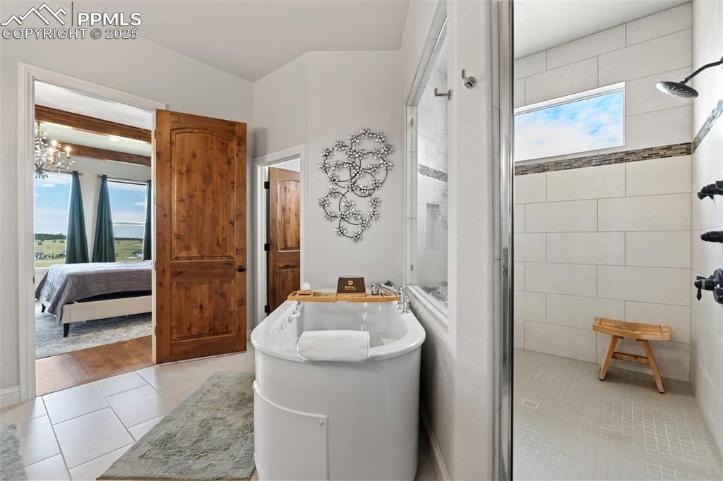 Image 34 of 50: Bathroom featuring a stall shower, light tile patterned floors, a freestand
