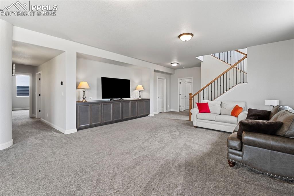 Image 39 of 50: Living area featuring carpet floors and stairs